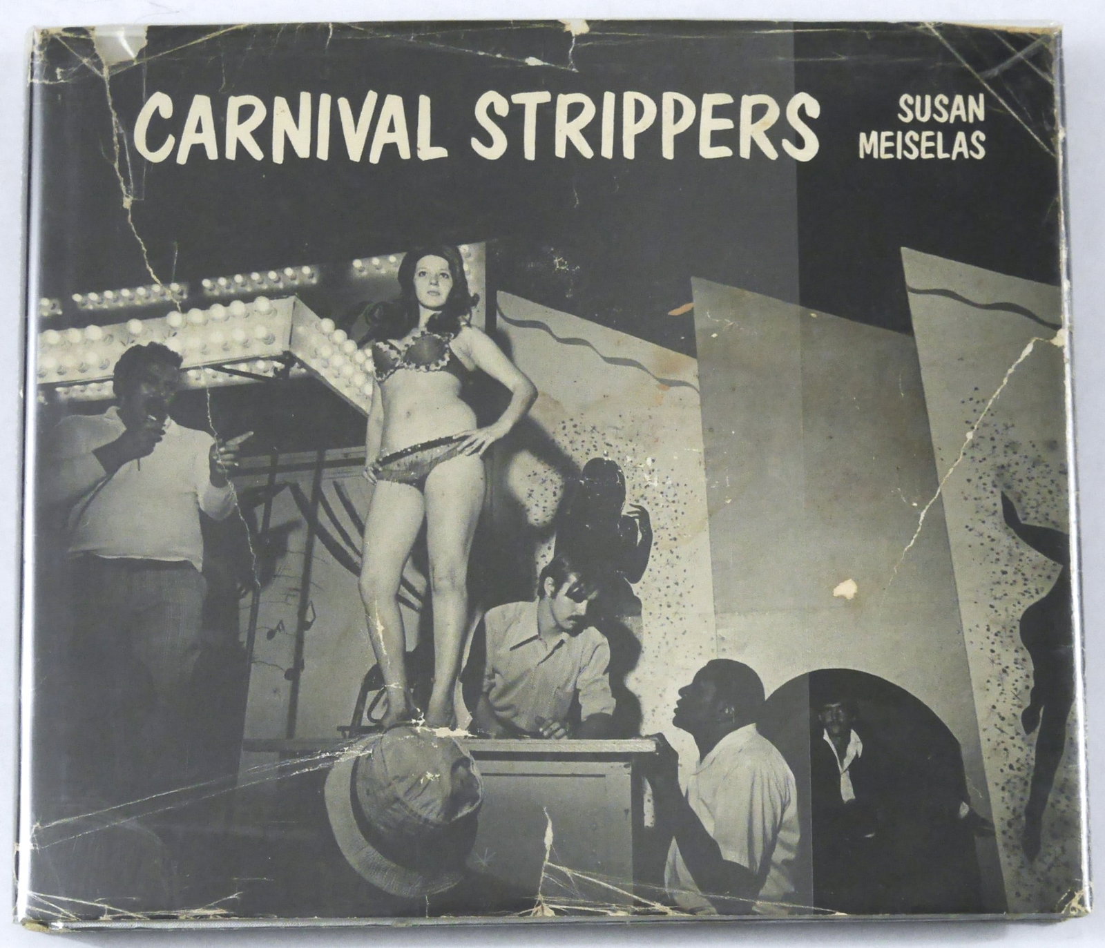 Meiselas, Susan; Carnival Strippers [1976 1ST EDITION & 1ST PRINTING HARDCOVER WITH DUST JACKET -: Farrar, Straus and Giroux 1976. Hardcover in silver/grey boards in pictorial dust jacket. First Edition, First Printing. Size: 8vo - over 7?" - 9?" tall. 150 pages with numerous black and white photog