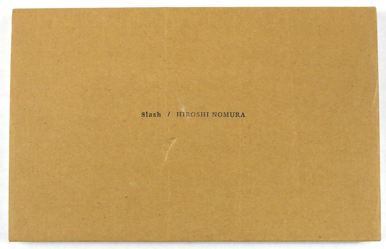 Nomura, Hiroshi; Slash [SIGNED LTD ED #/500]: N/T Works, 2010. Softcover housed in card slipcase. First Edition. Limited Edition of 500 numbered copies (this being #279) each signed by Hiroshi Nomura on the last page. 8 x 4 inches. 192 pages