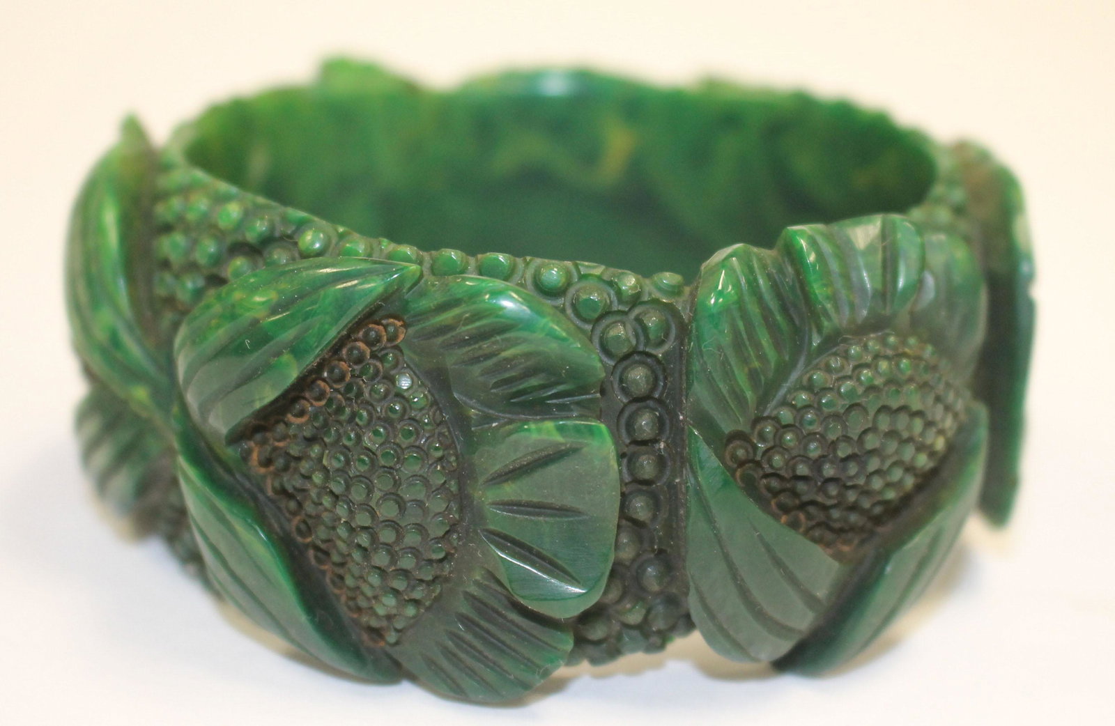 Bakelite reproduction marbled green bangle: Bakelite reproduction marbled green bangle w carved flower dec - 3 1/4" diam