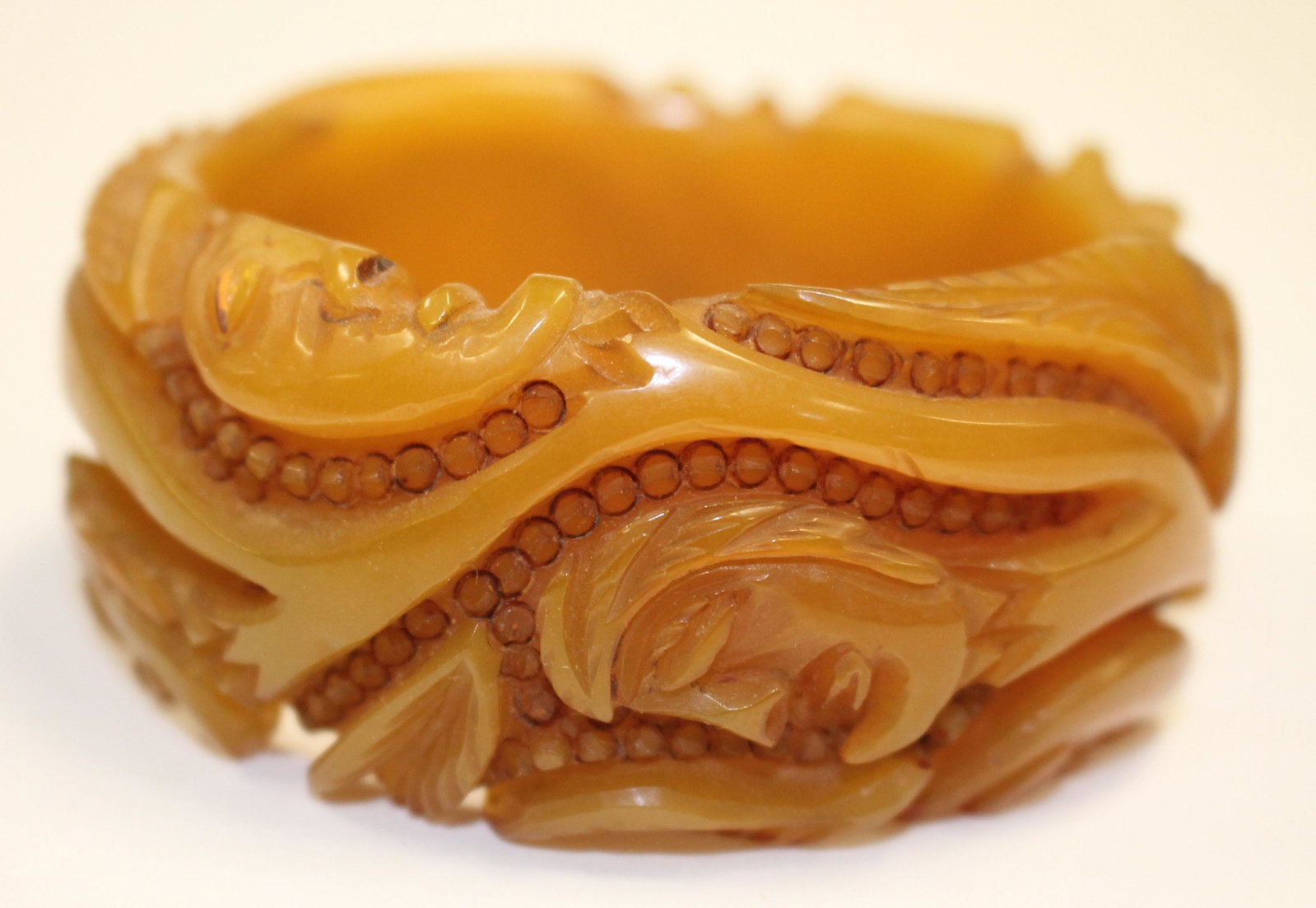 Bakelite reproduction bangle bracelet w carved face: Reproduction Bakelite bangle bracelet w carved face dec - 3 1/4" diam