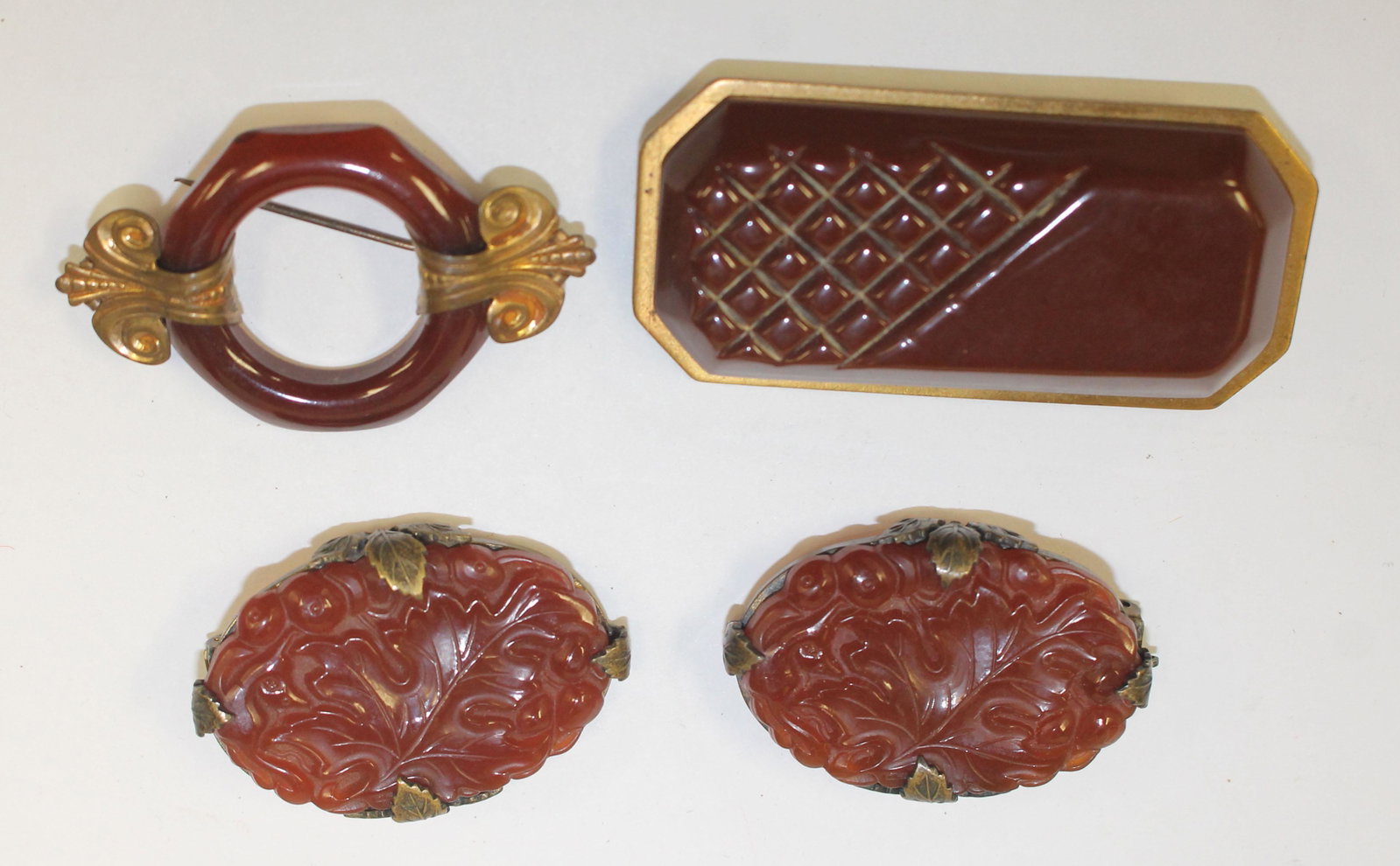 lot of 4 Vintage Bakelite reddish brown items incl pr: lot of 4 Vintage Bakelite reddish brown items incl pr of floral carved clips - 1 1/2", rectangular pin 2 1/4" & 2" diam w applied metal dec