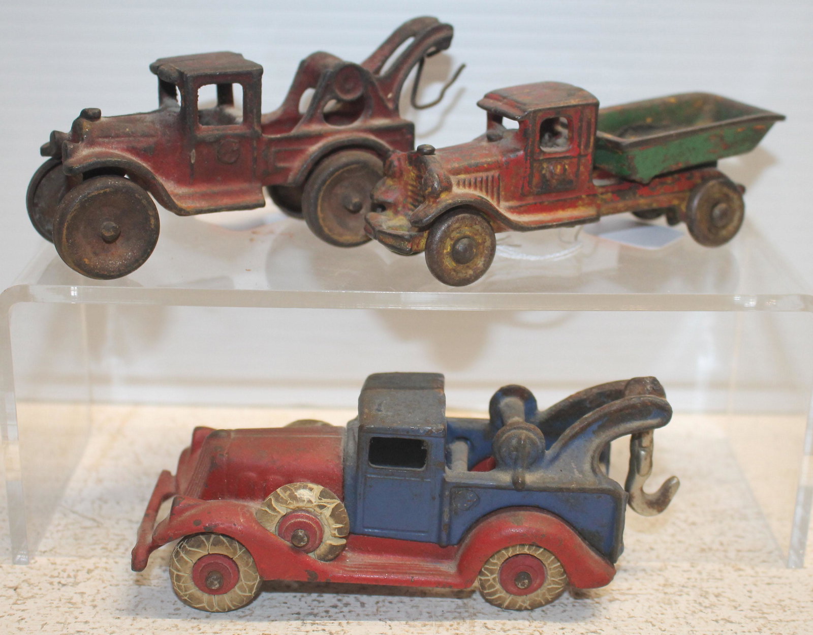 3 ca 1930's cast iron trucks incl Arcade 4 1/2" red tow: 3 ca 1930's cast iron trucks incl Arcade 4 1/2" red tow truck, red & 4 1/4" blue tow truck & 4 1/2" red & green dump truck