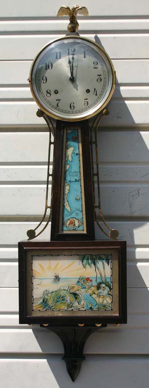 fine Ingraham 38" mahog cased banjo clock w "Treasu: fine Ingraham 38" mahog cased banjo clock w "Treasure Island" panel dec & brass eagle finial