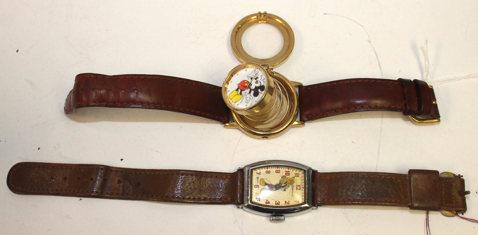 2 Walt Disney Productions Mickey Mouse wrist watcheson: 2 Walt Disney Productions Mickey Mouse wrist watcheson leather bands - 1 w spring loaded face - as is (no pin to hold it clocked)