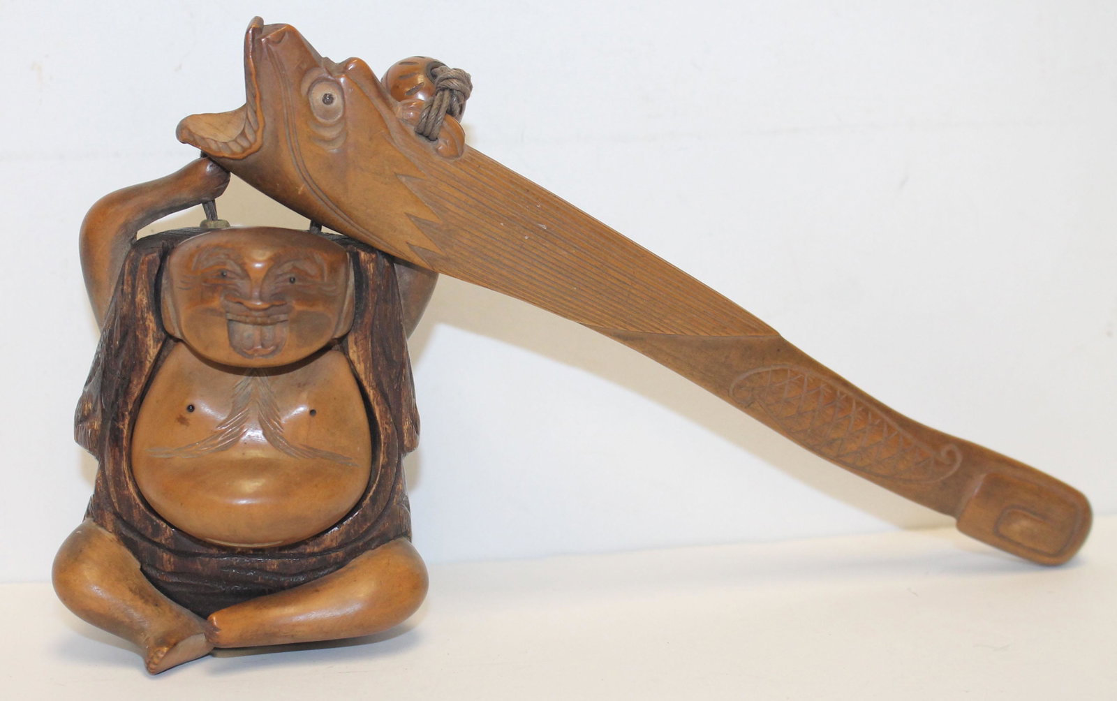 Carved fish form opium pipe w attached Buddha figural: Carved fish form opium pipe w attached Buddha figural opium holder - 8" long pipe; 3 1/2" tall Buddha