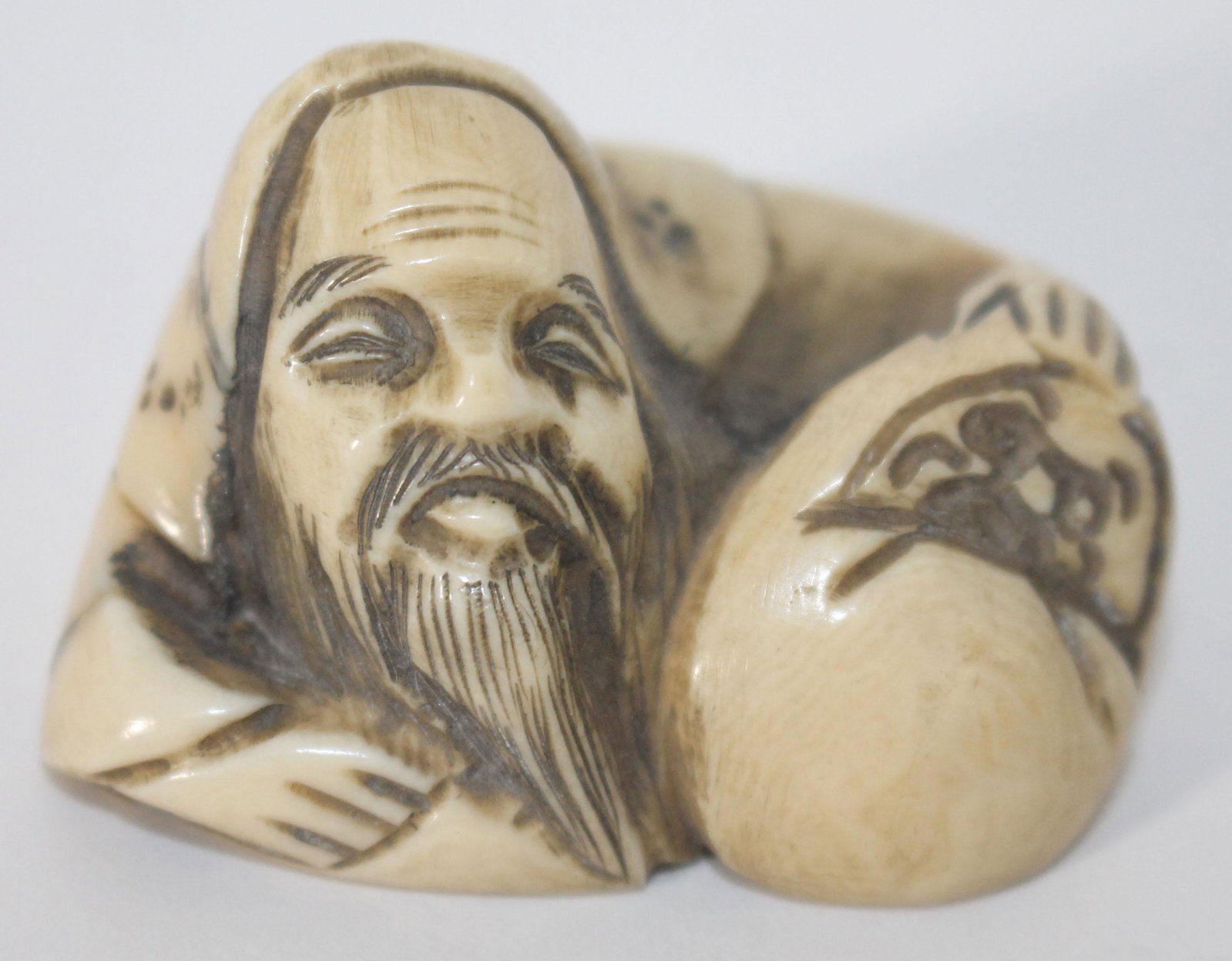 Japanese carved netsuke of a reclining scholar - sgnd -: Japanese carved netsuke of a reclining scholar - sgnd -