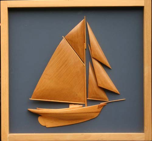 carved half model of a friendship sloop w carved &: carved half model of a friendship sloop w carved & varnished sails, hull & masts mounted to a painted panel - 16" tall x 17" wide