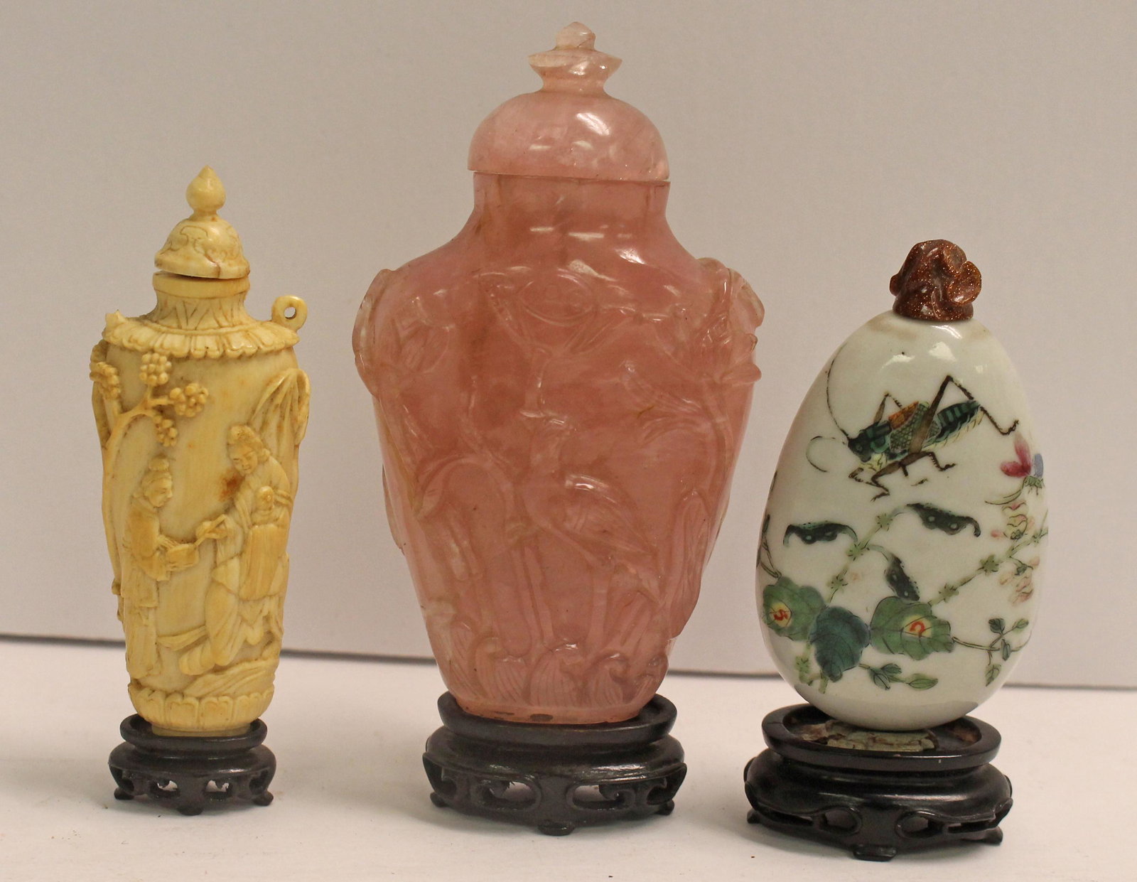 Lot of 3 Asian snuff bottles on wooden stands incl porcelain, bone & rose quartz - as found - approx: Lot of 3 Asian snuff bottles on wooden stands incl porcelain, bone & rose quartz - as found - approx 3" tall
