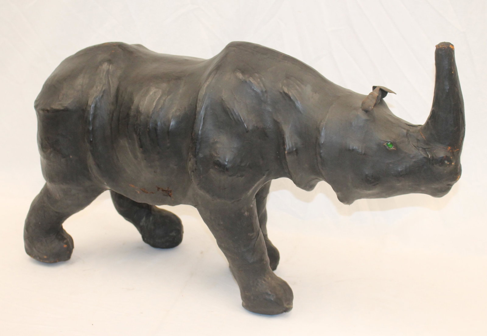 Leather composite sculpture/ottoman of a rhinocerous w leather ears & glass eyes: Leather composite sculpture/ottoman of a rhinocerous w leather ears & glass eyes by London - 29" long x 18" tall to top of horn