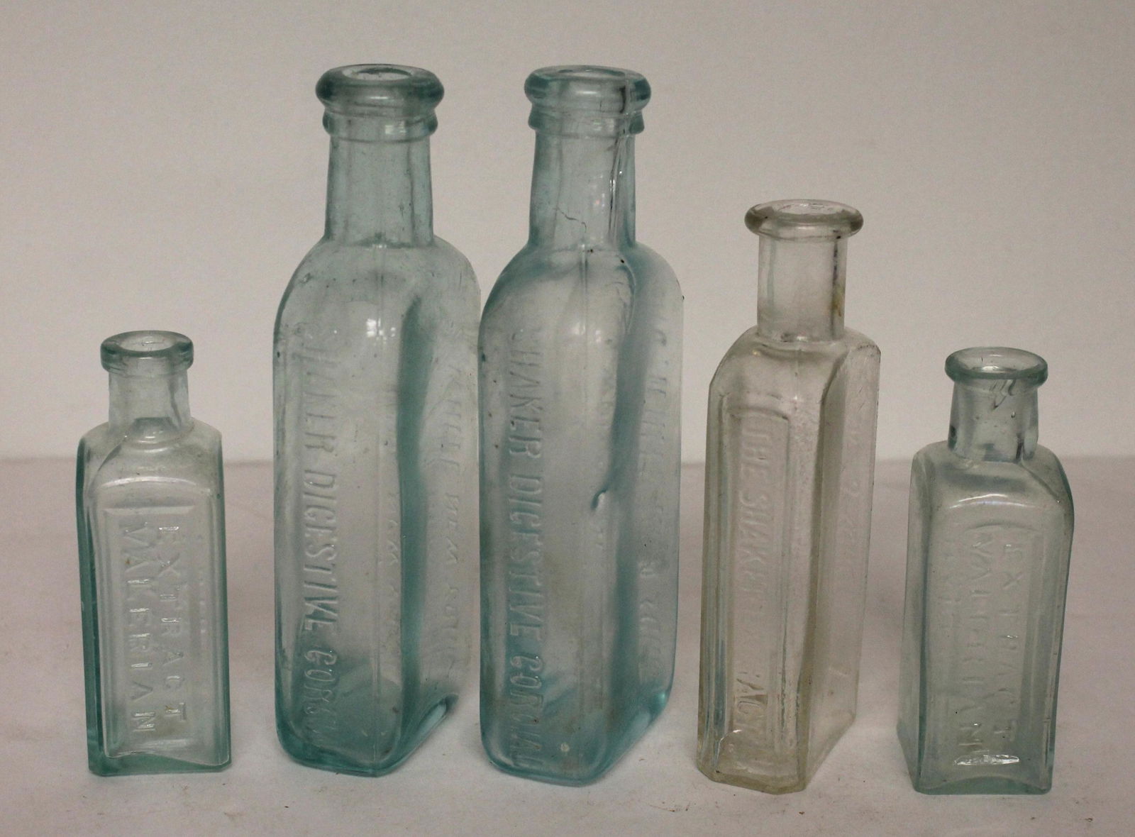 Shaker lot of 5 extract/cordial bottles - 4 in aqua & 1 clear - 3 1/2", 5" & 6" tall (1 of 6)