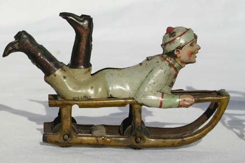 Fine antique German tin penny toy of boy on sled a: Fine antique German tin penny toy of boy on sled attrib to Meier - 3 3/4"