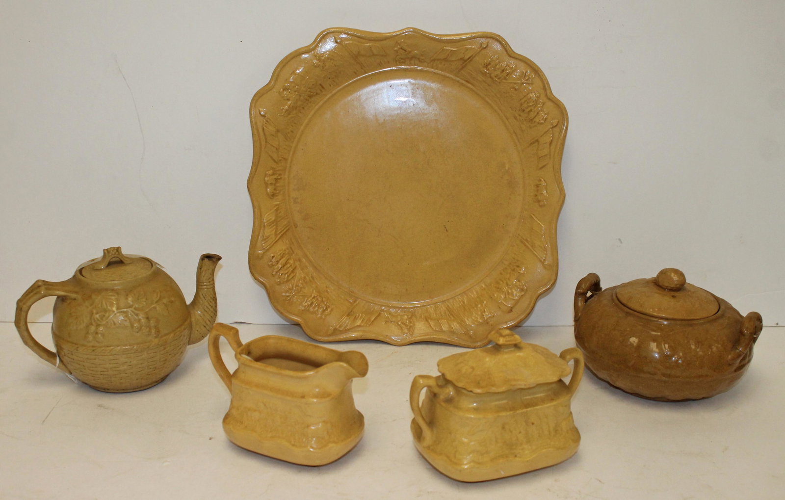 Lot of 5 pcs of antique yellowware incl creamer & sugar & platter w covered wagon motif, plus a: Lot of 5 pcs of antique yellowware incl creamer & sugar & platter w covered wagon motif, plus a teapot w grapevine motif & a covered sauce w berry motif