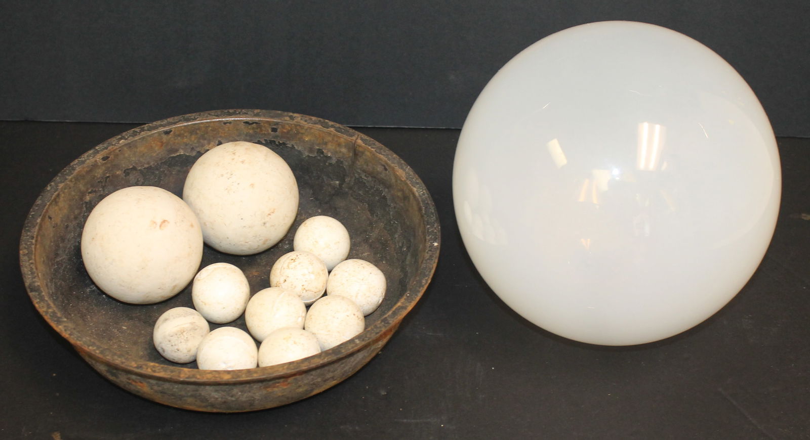 Lot of 11 filtration stones 1 1/2" - 3" together with an 8" white glass gazing ball in a round iron (1 of 4)