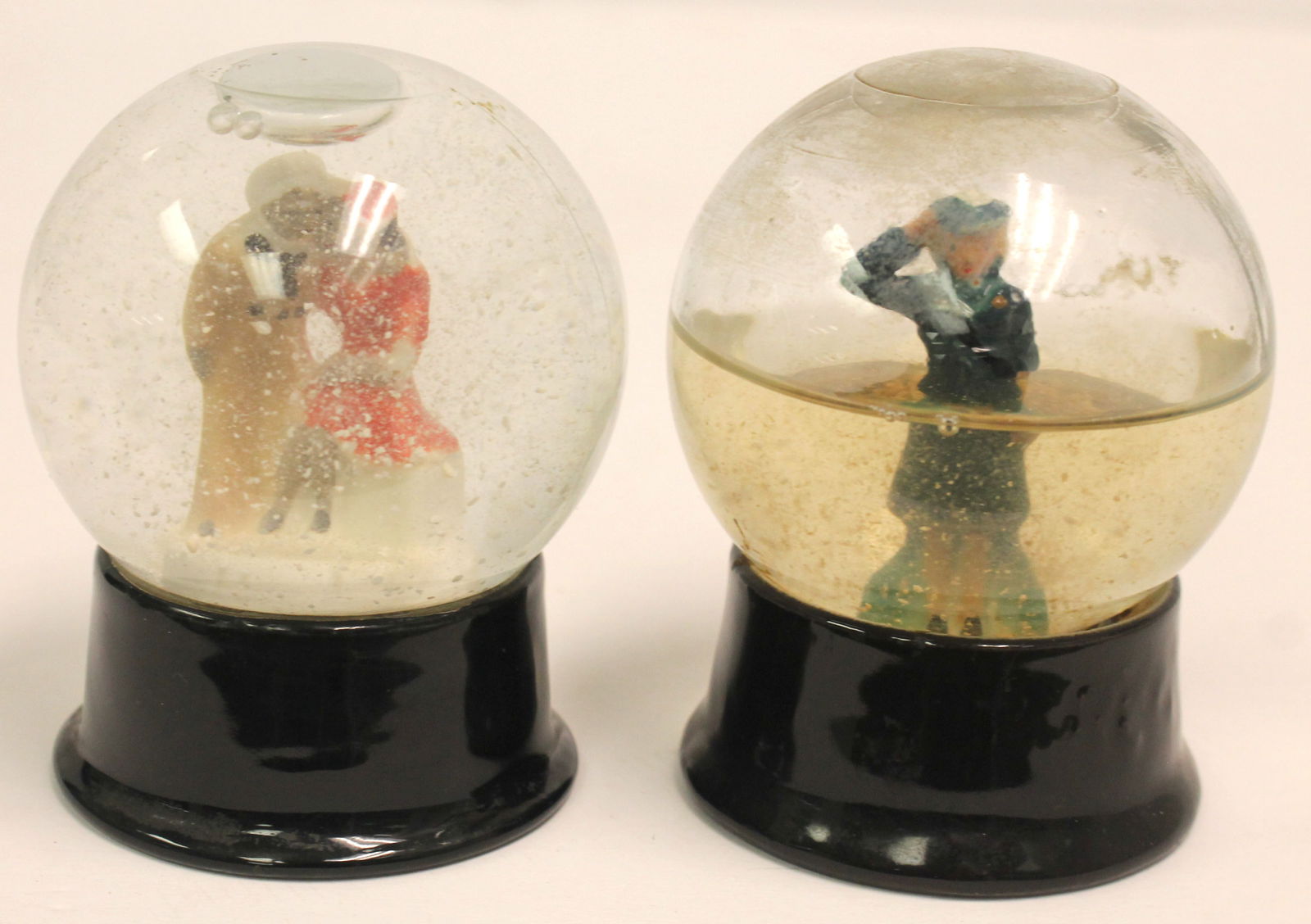 Lot of 2 vintage glass snow globes - Service woman soluting & A Sailor w woman kissing him - Approx (1 of 6)
