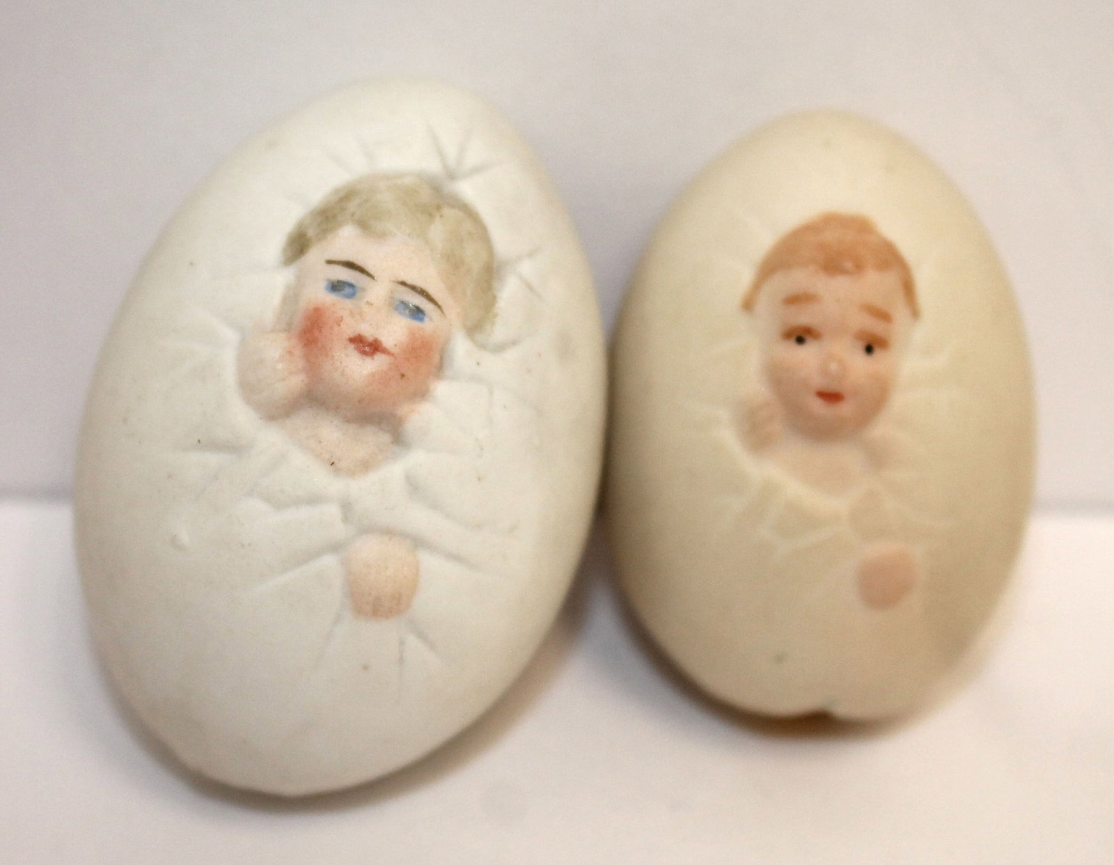 lot of 2 ceramic eggs w baby faces & back sides - 2" & 1 3/4": lot of 2 ceramic eggs w baby faces & back sides - 2" & 1 3/4"