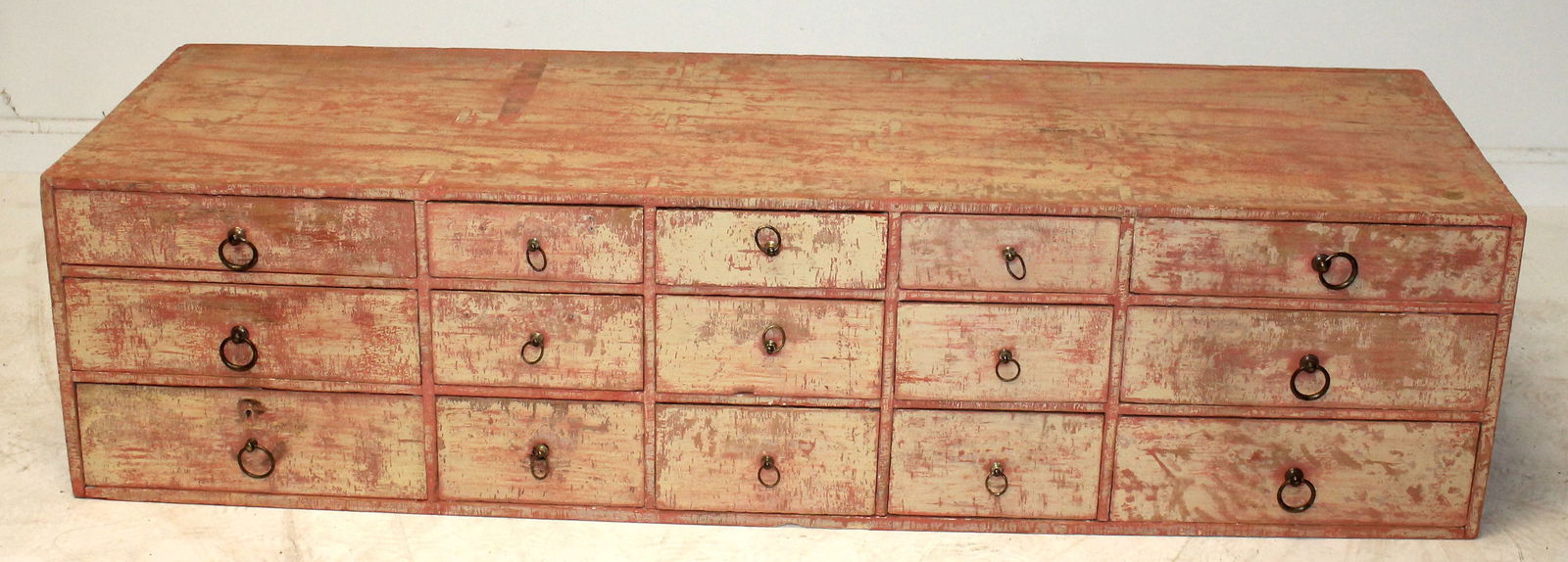 Antique set of drawers (15) in salmon paint - 12" tall x 48" long x 15" deep (1 of 10)