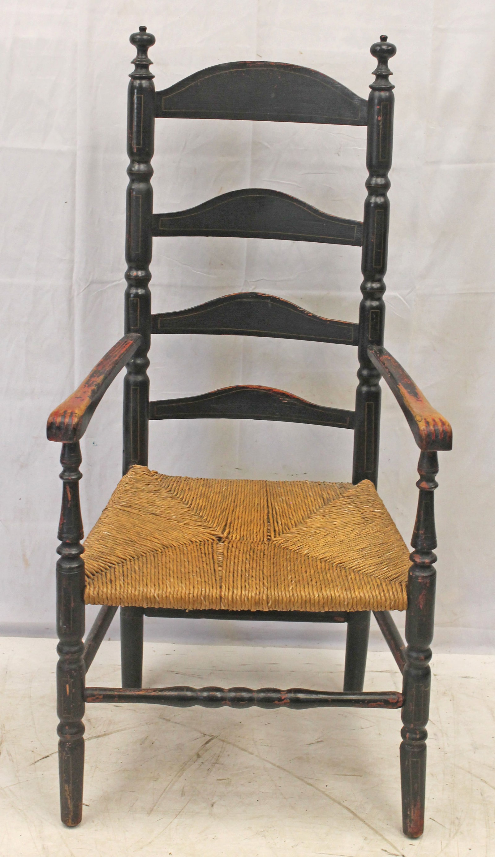 Antique ladderback armchair w knuckle arms in black over red paint w rush seat - as found - 49" w: Antique ladderback armchair w knuckle arms in black over red paint w rush seat - as found - 49" w 17" seat height