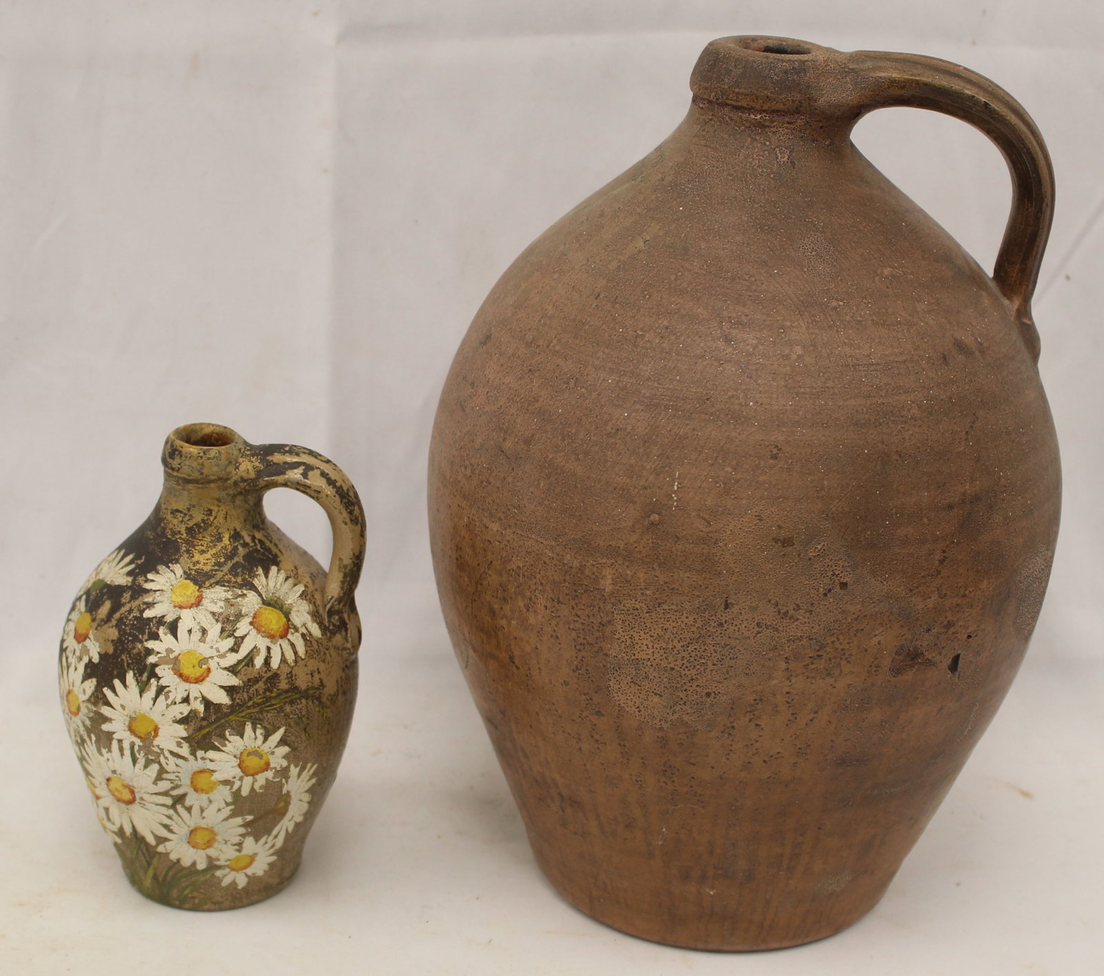 Lot of 2 stoneware ovoid jugs incl a 12" marked T.Crafts Whately and the other 7" with later painted: Lot of 2 stoneware ovoid jugs incl a 12" marked T.Crafts Whately and the other 7" with later painted daisy decoration