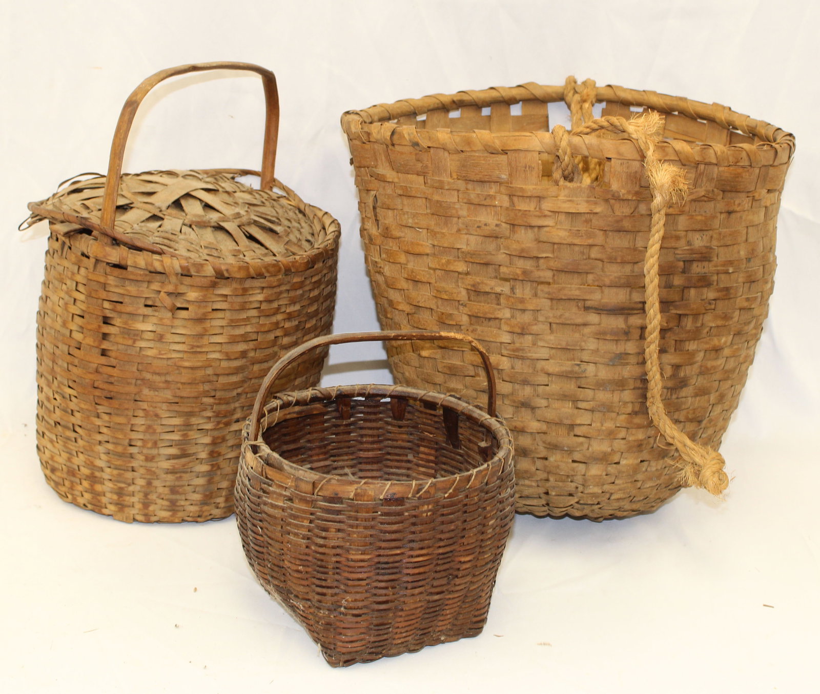 Lot of 3 antique baskets incl a fixed handled covered example, a feed basket & a fixed handled -: Lot of 3 antique baskets incl a fixed handled covered example, a feed basket & a fixed handled - 15"x10" diam 14"x14" diam & 9"x8" diam