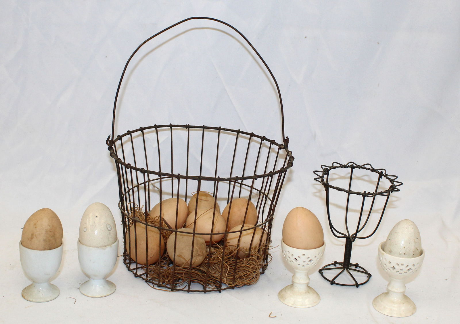 Lot of 2 antique wire baskets plus 4 porcelain & ironstone egg cups & eggs (2 ironstone - mostly (1 of 4)