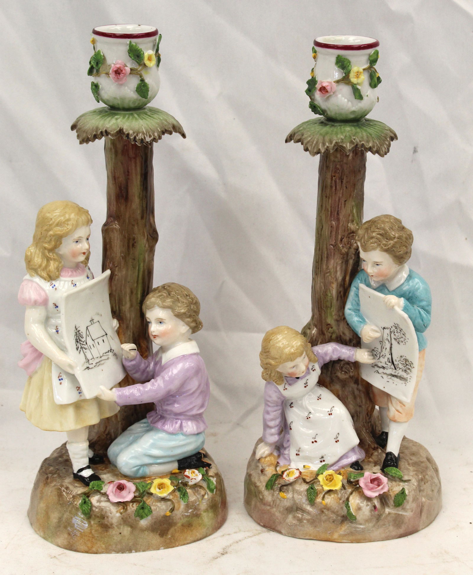 Pair of porcelain figural candelsticks of young boy & girl holding drawings (1 of 7)
