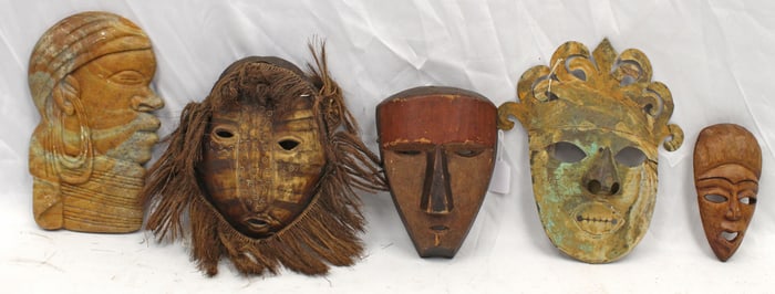 Collection of Haitian masks in carved wood, tortoise, tin & a stone bust