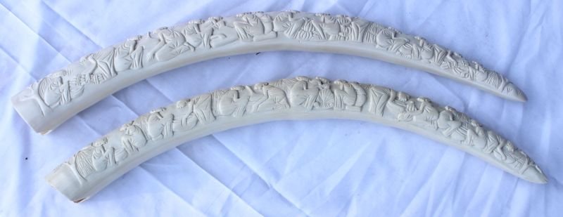 Magnificent pr of antique African ivory carved tu: Magnificent pr of antique African ivory carved tusks featuring multiple people & village activities on both sides of each - 25"