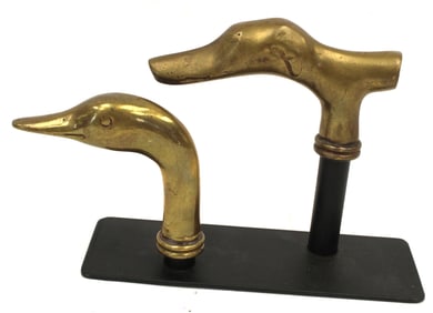 Lot of 2 brass figural cane handles of a duck & a dog on display stand - 6" tall x 8" wide overall