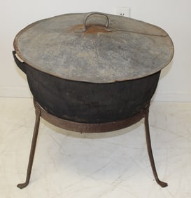 Large antique iron cauldron w bail handle sitting in iron stand w added tin lid - 23" diam cauldron