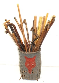 Paint decorated tall basket filled with canes & walking sticks