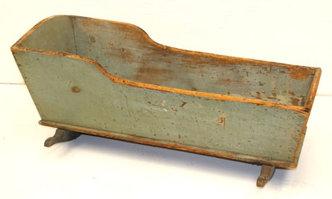 Antique wooden cradle in green paint
