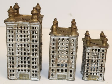 Lot of 3 antique cast iron graduated size buildings still banks in silver & gold paint - 3 1/2", 4