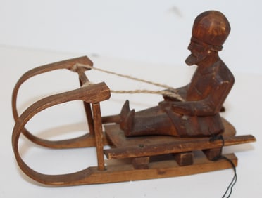 Carved wooden figure on sled - 4" tall x 6" wide