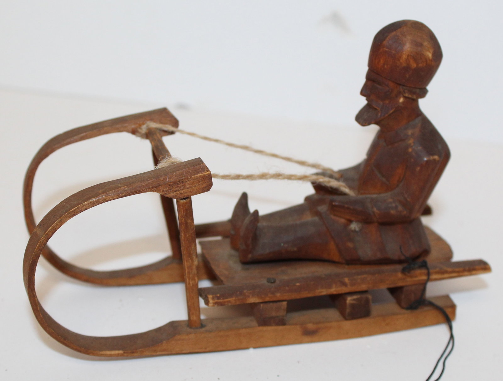 Carved wooden figure on sled - 4" tall x 6" wide: Carved wooden figure on sled - 4" tall x 6" wide