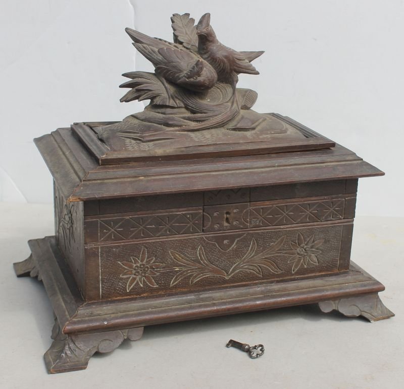 Black Forest carved lift top footed box or jewelry cask: Black Forest carved lift top footed box or jewelry cask w double bird carved finial & secret compartment lock & key -10" wide x 8 1/4" tall