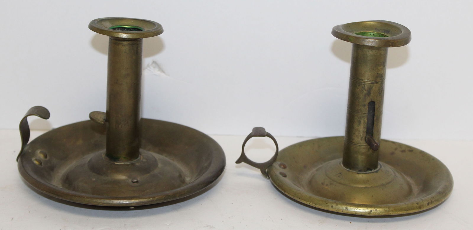 Lot of 2 antique brass push up chamber sticks - 5" tall x 5" diam: Lot of 2 antique brass push up chamber sticks - 5" tall x 5" diam