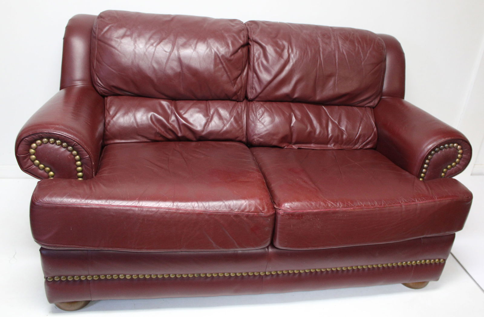 Thomasville Burgundy leather over stuffed loveseat - 34" tall x 66" wide x 33" dee: Thomasville Burgundy leather over stuffed loveseat - 34" tall x 66" wide x 33" dee