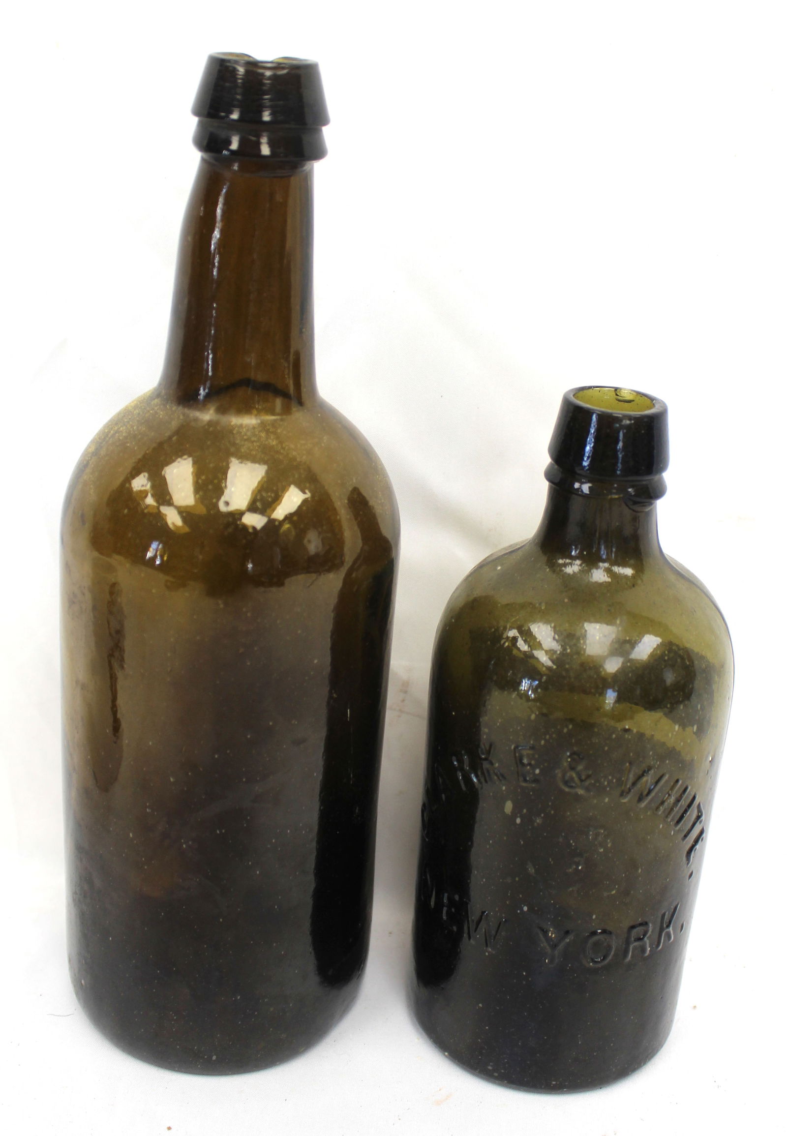 Lot of 2 early glass bottles incl amber & green "Clarke & White New York" - 7 1/2" & 10" tall: Lot of 2 early glass bottles incl amber & green "Clarke & White New York" - 7 1/2" & 10" tall
