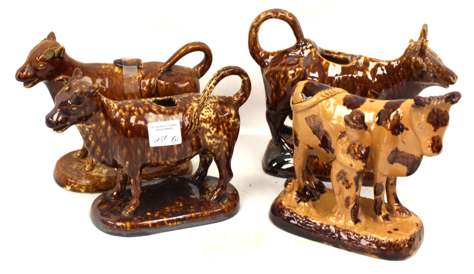 Lot of 4 Bennington figural cow creamers (3) and a figure - 5 1/4" - 5 1/2" tall: Lot of 4 Bennington figural cow creamers (3) and a figure - 5 1/4" - 5 1/2" tall