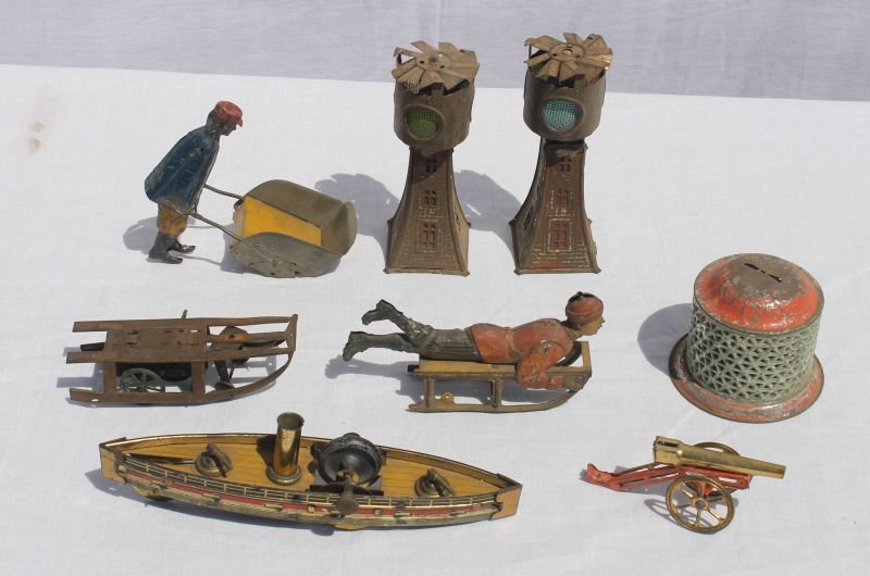 lot of as found antique German toys incl boy on sled,: lot of as found antique German toys incl boy on sled, Porter, weight driven boat, early tin bank, etc (8 items)
