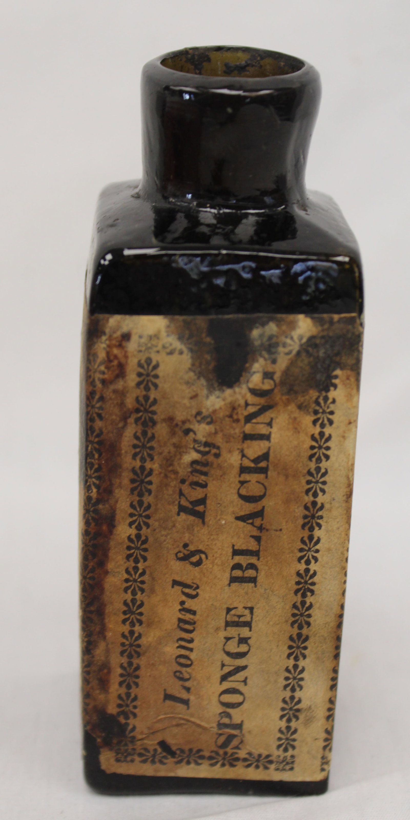 Early dark green/black glass bottle w orig label - 4 1/2" tall - 2