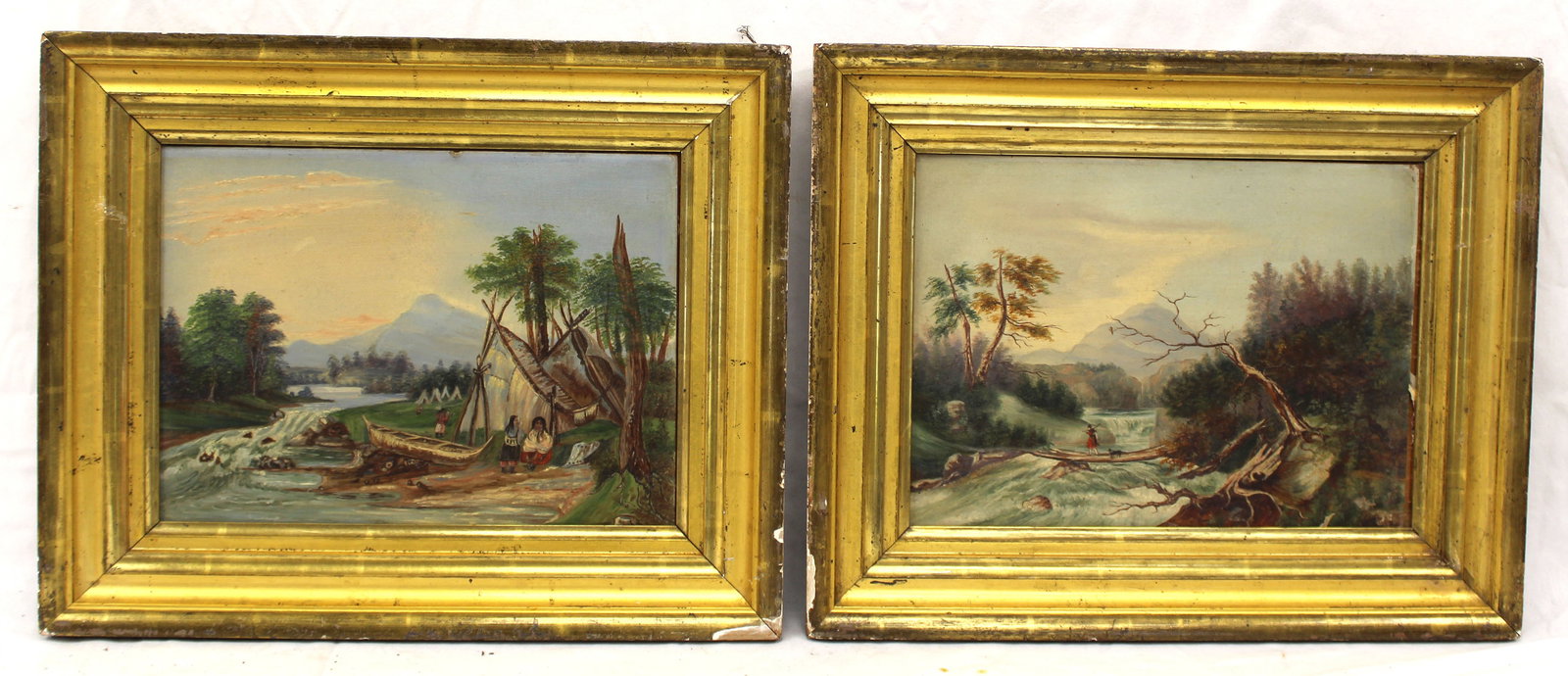 Lot of 2 antique o/bd riverscapes w mountains in background in matching frames - 1 w Indian: Lot of 2 antique o/bd riverscapes w mountains in background in matching frames - 1 w Indian Encampment scene w figures, teepees & canoe & the other w woman & dog walking over log bridge - overall fram
