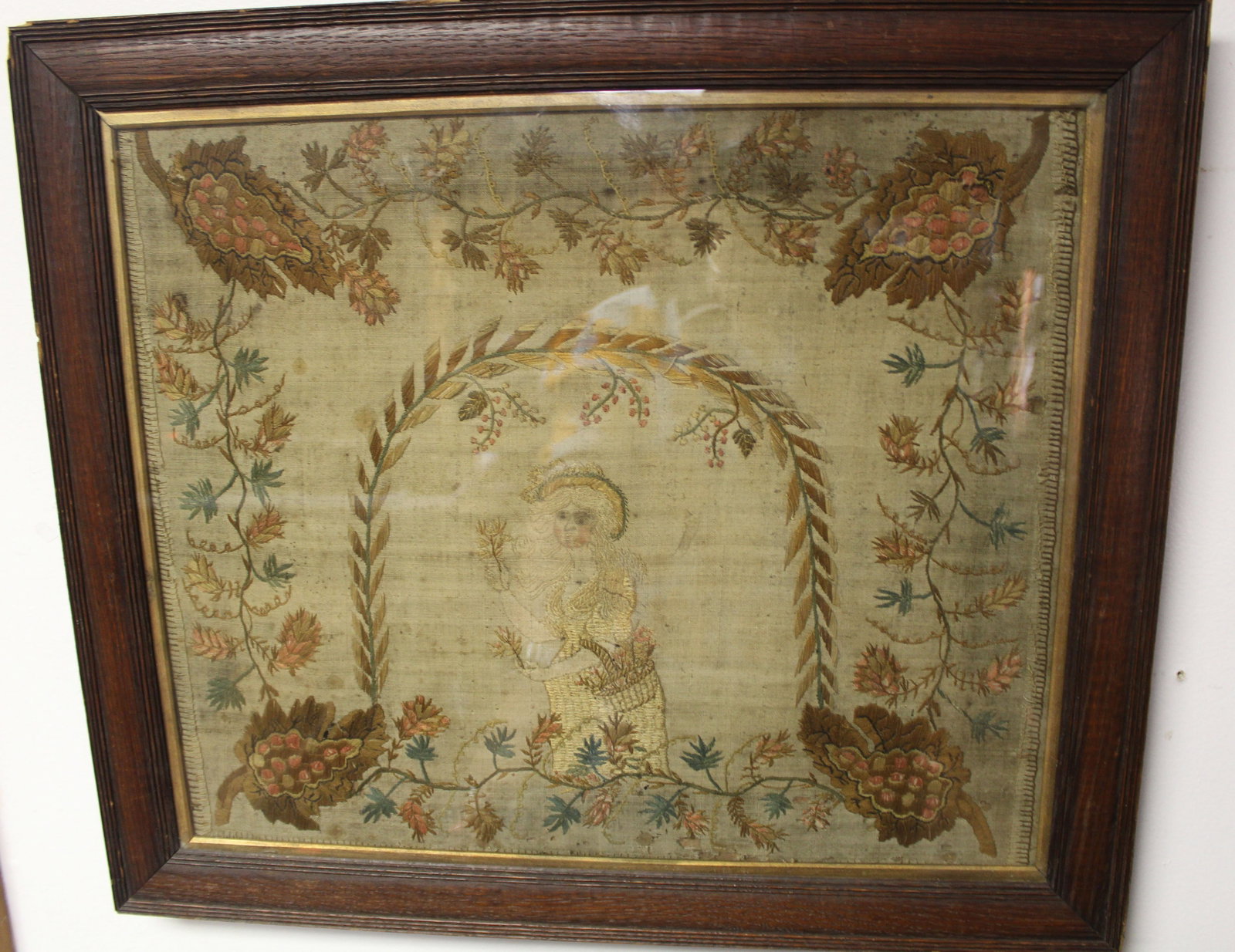 Antique framed embroidery of woman carrying basket of flowers surrounded by leaf & floral dec border (1 of 7)