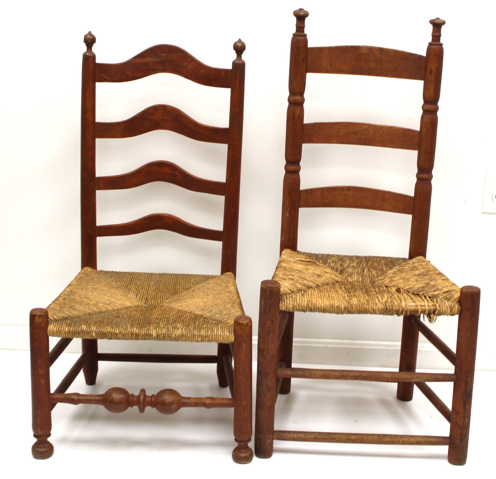 Lot of 2 antique ladderback chairs in red paint w rush seats - 35" tall w 12" seat height & 38" tall