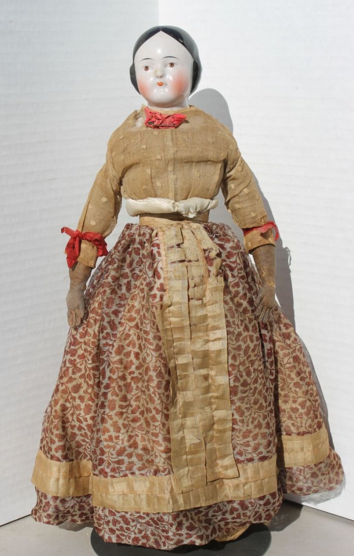 ca 1860-70 black haired china shoulder head w brown: ca 1860-70 black haired china shoulder head w brown eyes, leather forearms, cloth body & lower limbs (missing right thumb) - in antique clothes w trunk & more clothes - 16" tall