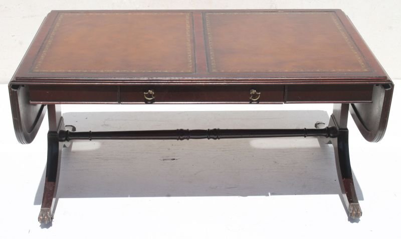 20thC mahog dropleaf coffee table w drawer & dbl inset: 20thC mahog dropleaf coffee table w drawer & dbl inset tooled leather top on Duncan Phyfe type legs ending in brass paw feet & casters - 53 1/2" long