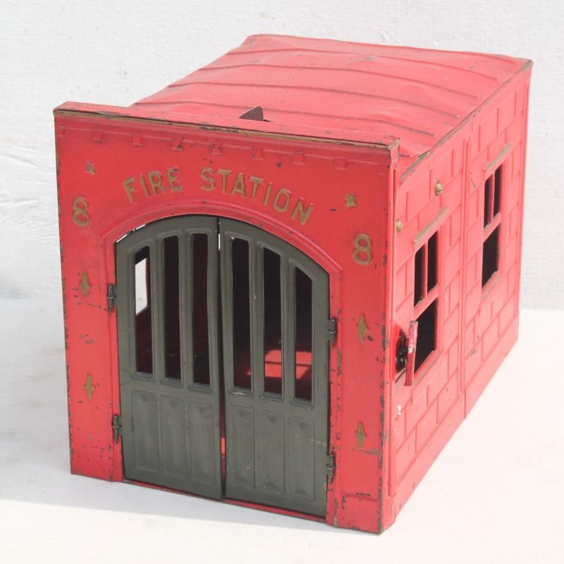Early 20thC Kingsbury pressed steel toy "Fire Station: Early 20thC Kingsbury pressed steel toy "Fire Station 8" in orig red paint & gold lettering w green doors, working bell mechanism on top & working door release lever on side of building - 10"x8"x13 1/