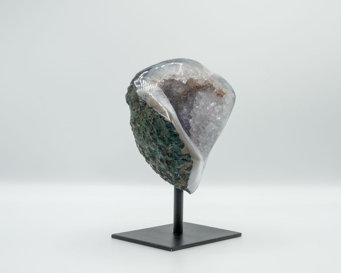 Small Amethyst and Agate Geode on Stand: Small amethyst and agate geode with polished edges on black metal stand. 7” x 4.5” x 3”. 3.7 pounds.