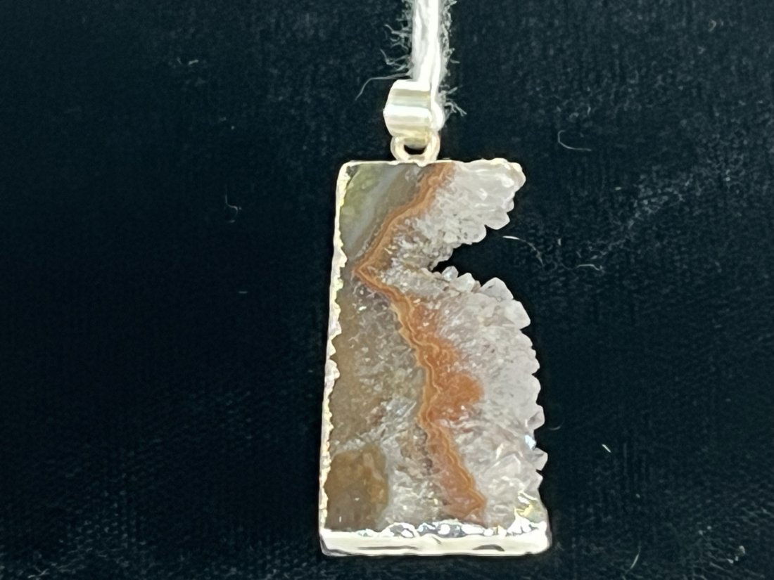 Amethyst Cross-Section Pendant: Amethyst cross-section pendant with silver-colored plating on edges.