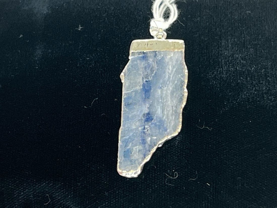 Blue Kyanite Pendant: Blue kyanite pendant with silver-colored plating on edges.